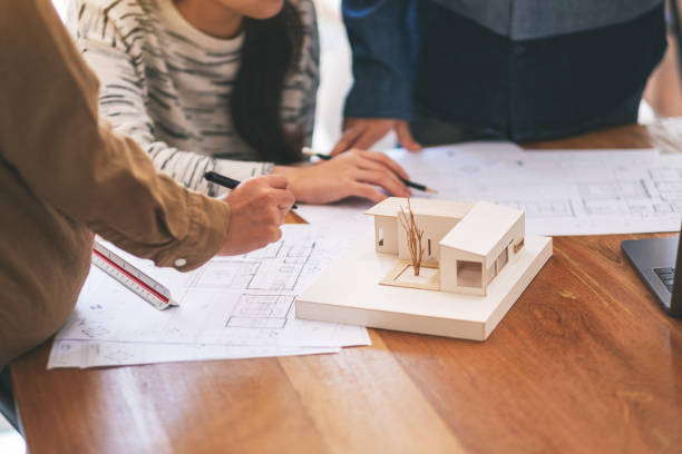 istock an architect working and discussing about an architecture model together 1154929787