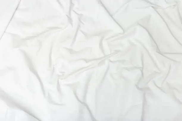 Photo of Crumpled white sheet.  Textile background. Fabric texture. Natural cotton sheet