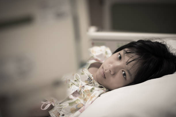 Asian kid patient child girl inpatient sad look at IV infusion drop for on hospital bed. Cancer chemotherapy chemo medical healthcare concept Asian kid patient child girl inpatient sad look at IV infusion drop for on hospital bed. Cancer chemotherapy chemo medical healthcare concept inpatient stock pictures, royalty-free photos & images