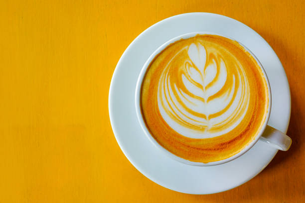 istock Latte Coffee art on the wooden table yellow 1154935583