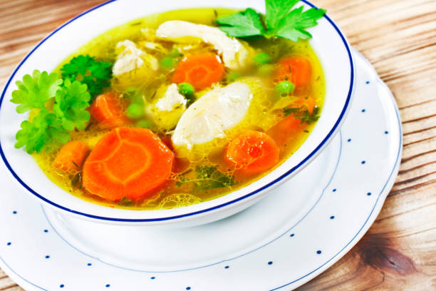 istock Chicken soup and wooden background close up 1154937243