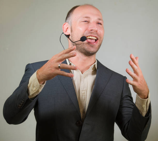 istock happy attractive and confident business man speaker with headset giving coaching conference training for job success smiling cheerful and positive isolated on grey background 1154938526
