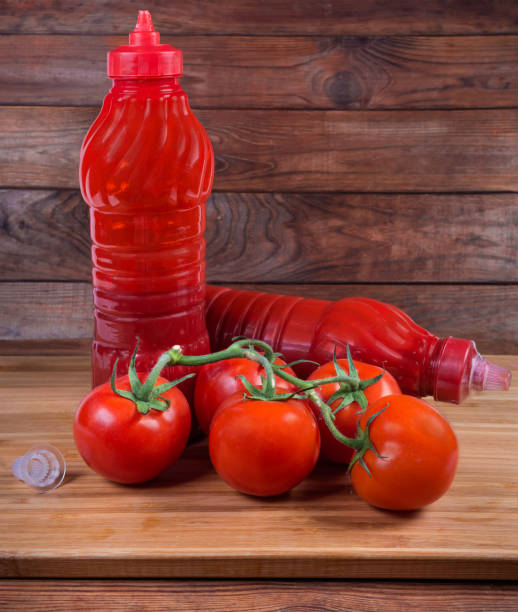 istock Tomato sauce in two plastic bottles and tomatoes branch 1154938652