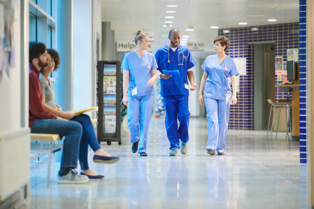 krankenschwestern plaudern auf dem weg zur station - nhs stock-fotos und bilder