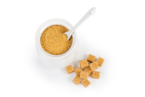 Top view of brown sugar in sugar-bowl, sugar cubes