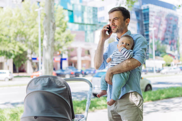 istock Father and baby son walk, interrupted by phone call 1154940736