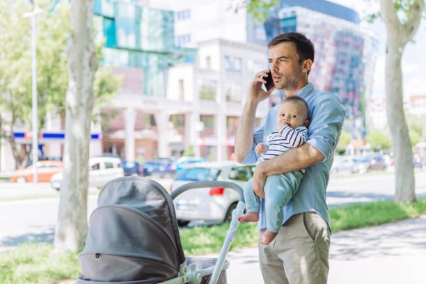 istock Father and baby son walk, interrupted by phone call 1154940835
