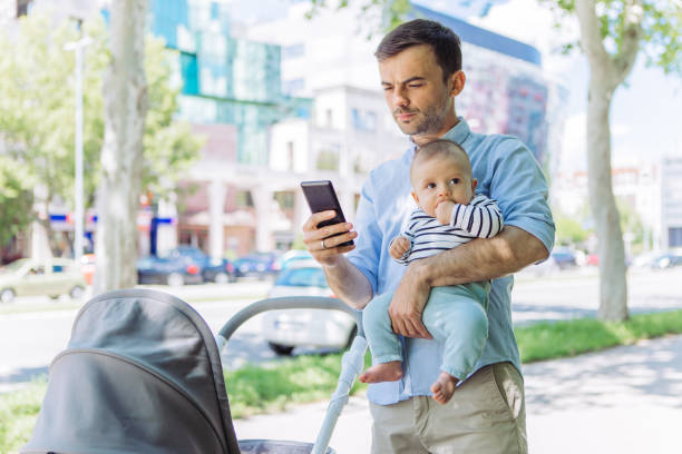 istock Father and baby son walk, interrupted by phone call 1154940836
