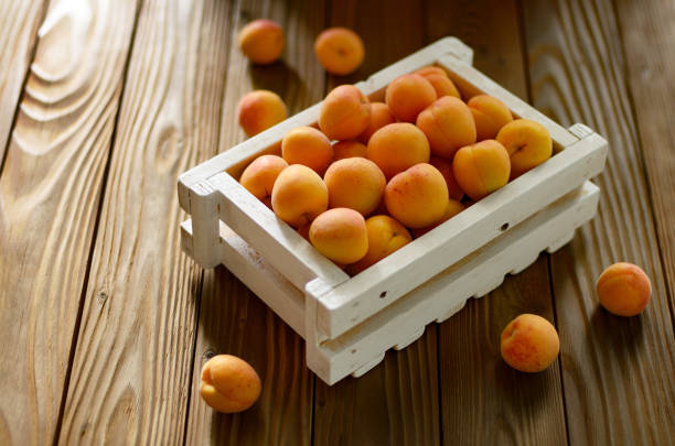 istock White wooden crate with apricots on table 1154944617