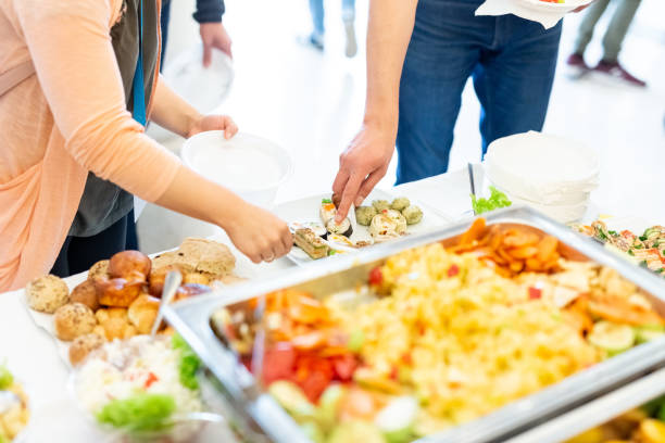 istock Female hands picking up food from platter. Event wedding buffet concept. 1154945957