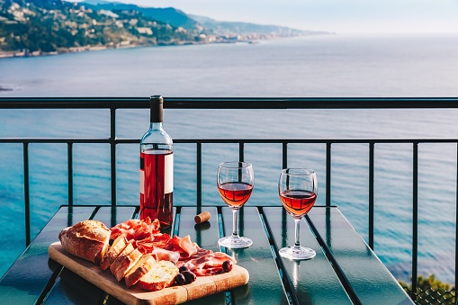 Two glasses of wine and italian snacks  with amazing view at sunset in Italy. Romantic dinner for two on panoramic terrace