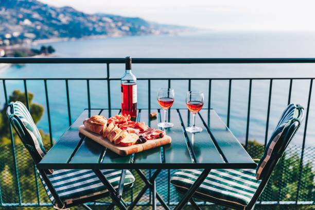 Two glasses of wine and italian snacks  with amazing view at sunset in Italy. Two glasses of wine and italian snacks  with amazing view at sunset in Italy. Romantic dinner for two on panoramic terrace wine italian culture wine bottle bottle stock pictures, royalty-free photos & images