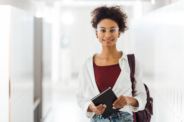 istock front view of african american student with notebook in corridor in university 1154947684