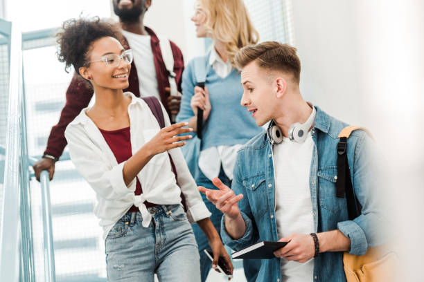 istock four smiling multiethnic students with backpacks on stairs 1154947793