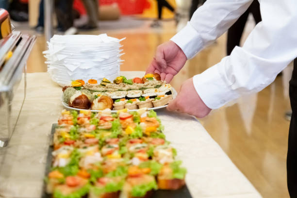 istock Waiter bringing plate full of delicious snacks on table. 1154947889