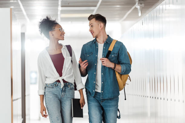 istock two multiethnic students looking at each other in corridor in university 1154947945