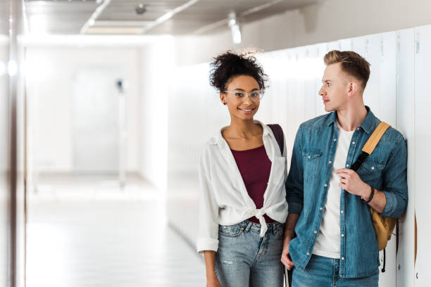 istock two multiethnic students standing in corridor in university 1154947950