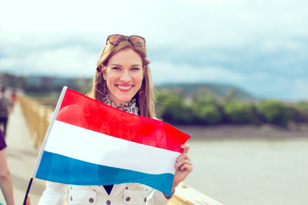 istock Happy young woman holding Dutch flag graded 1154948209