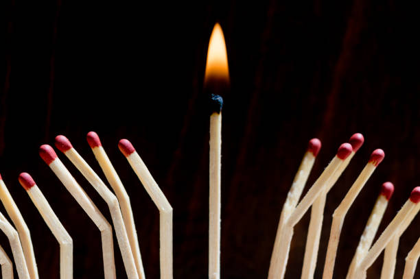 istock Many matches on a black background ,one match burns 1154949029