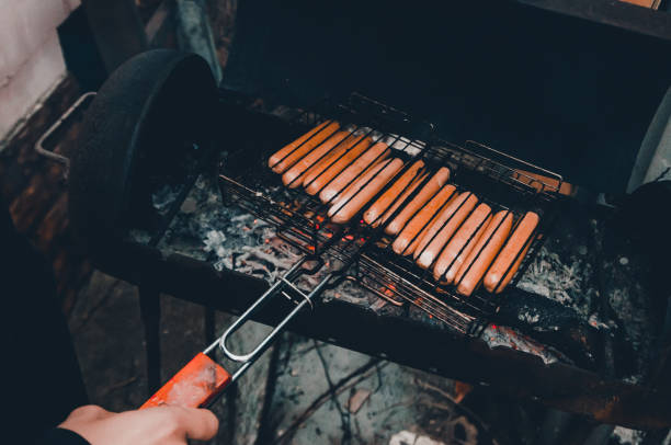 istock man frying sausages on fire 1154949146