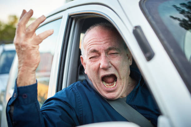 istock Outraged senior male driver gestures angrily through car window 1154950764
