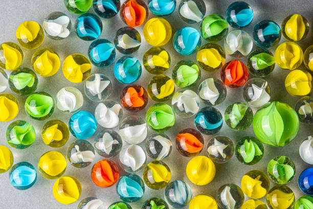 istock Yellow, green, blue and red glass marbles on a table. 1154953346