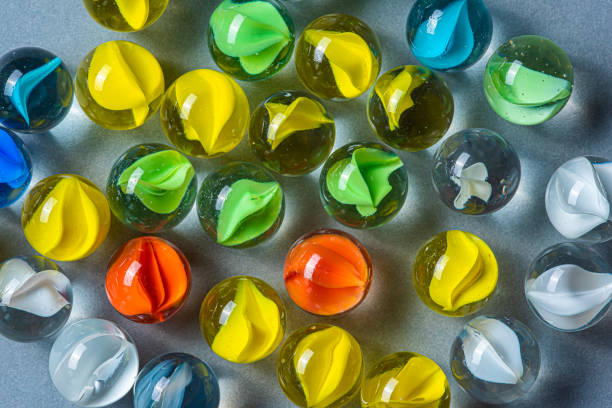 istock Yellow, green and red glass marbles on a table. 1154953424