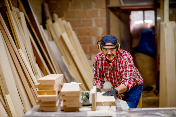 istock Carpenter sawing a board with a table saw 1154956477