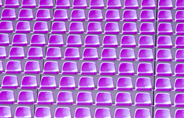 istock Empty violet plastic chairs in a row at the football stadium 1154956620