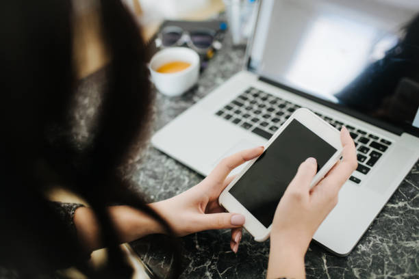 Woman working from home with smartphone.