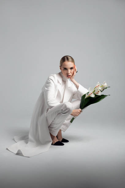 istock Modern bride in white total look with white orchid 1154960779