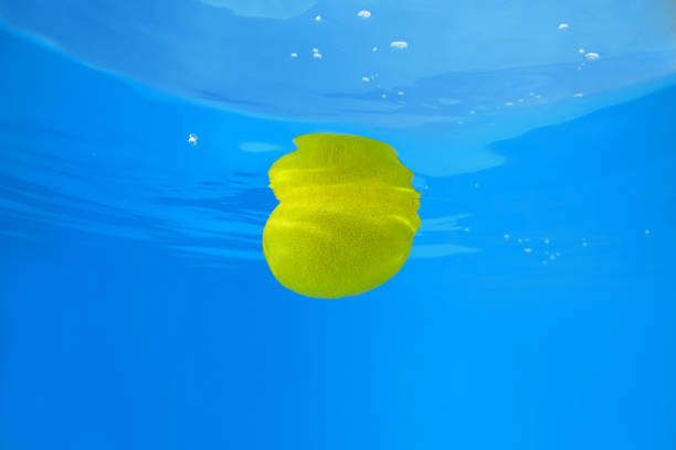 Lemon splashing in blue water. Underwater shot