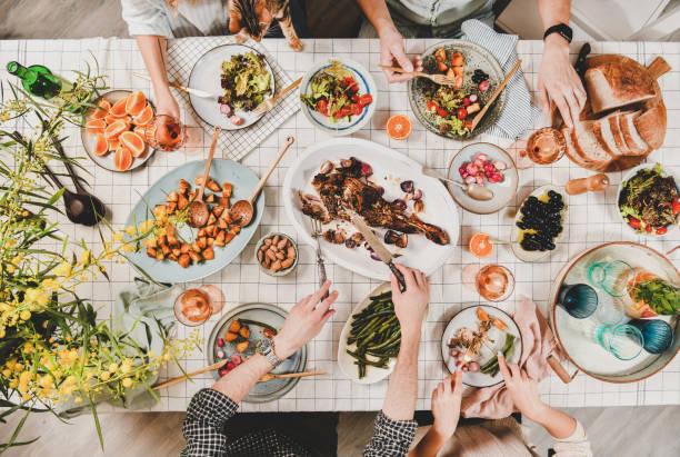 istock Peoples hands with lamb, salads, snacks and blooming mimosa, flat-lay 1154961220