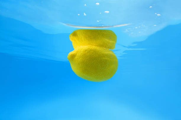 Lemon splashing in blue water. Underwater shot