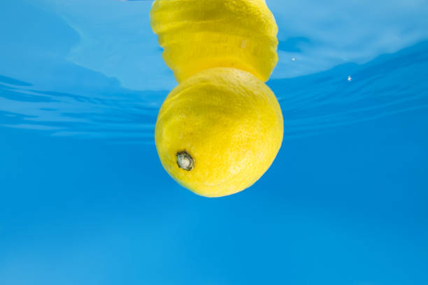 Lemon splashing in blue water. Underwater shot