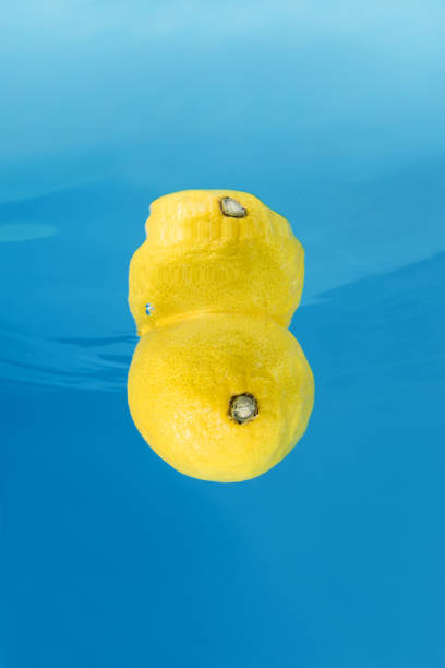 Lemon splashing in blue water. Underwater shot
