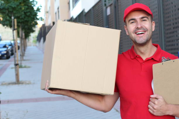 istock Delivery man holding a box outdoors 1154962815