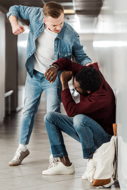 istock two multiethnic students fighting in corridor in college 1154963572