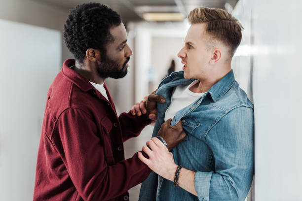 istock two multiethnic students fighting in corridor in college 1154963599