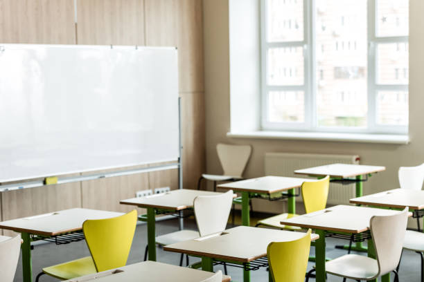 istock classroom with wooden desks, chairs, window and flipchart 1154963619