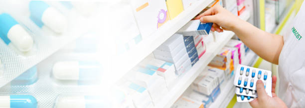istock Pharmacist holding medicine box and capsule pack and blue capsule pack background 1154964034