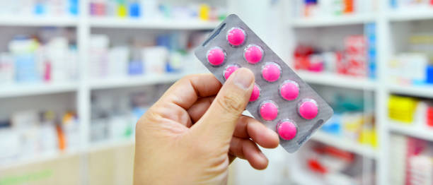 istock Pharmacist holding medicine capsule pack in pharmacy store 1154964238