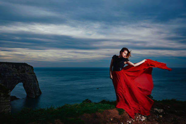 istock fashion model in windy landscape 1154966798