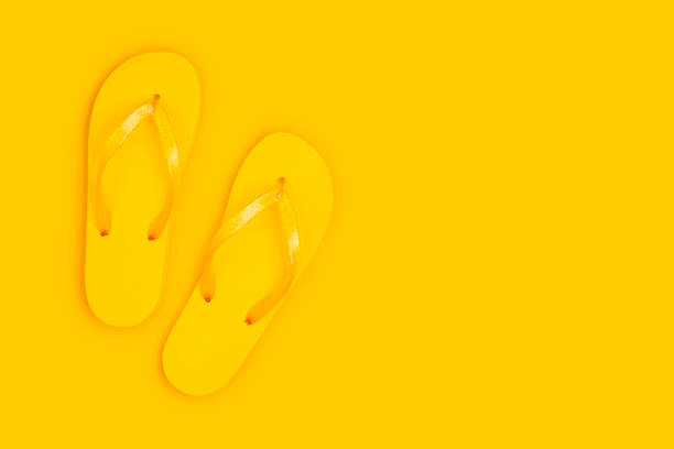 istock Flip flop slippers with copy space on yellow background 1154967358