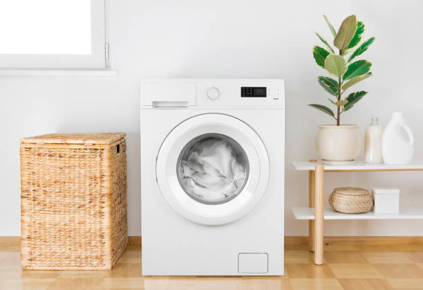 istock Washing machine with clothes in modern bathroom interior 1154970679
