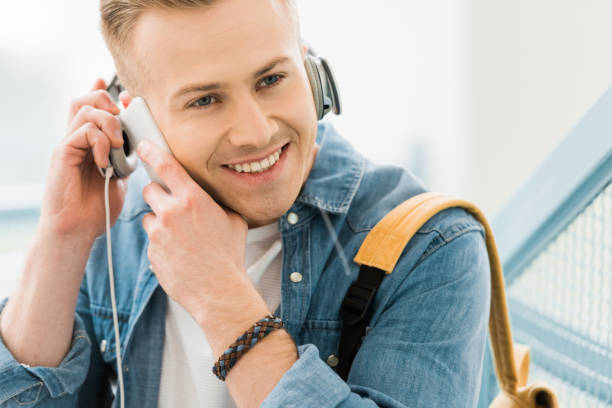 istock smiling student in headphones talking on smartphone in university 1154970914