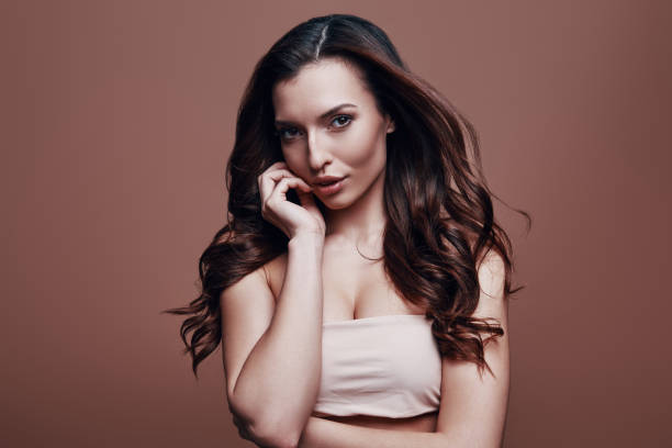 istock Effortless beauty. Attractive young woman looking at camera while standing against grey background 1154973226