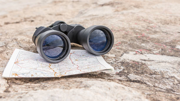 istock the binoculars on the old map orienteering Hiking direction stone background 1154973350