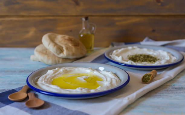 labneh or labaneh middle eastern soft goat's milk cheese with olive oil, za'atar or hyssop, pita bread stock photo