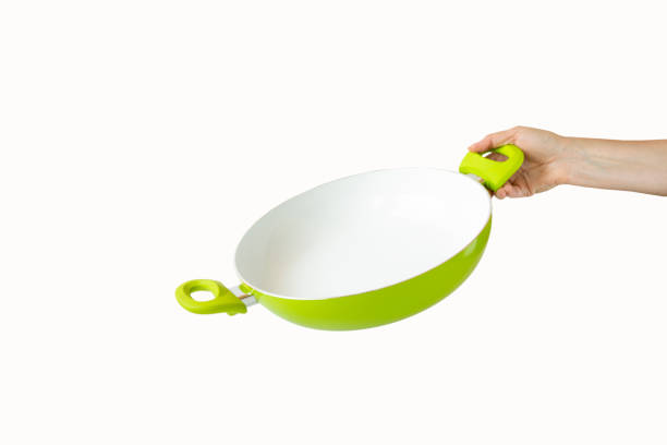 istock A woman's hand holding a frying pan. Isolated objects on white background 1154975738